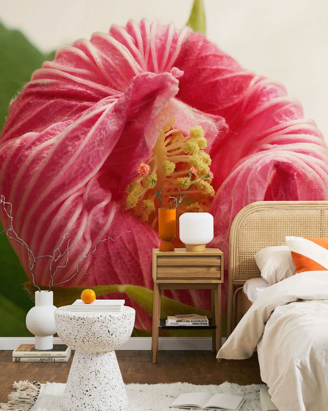 Blossoming Pink Hibiscus Floral Wallpaper with rattan bed, modern side table, terrazzo accent table, wooden floor.