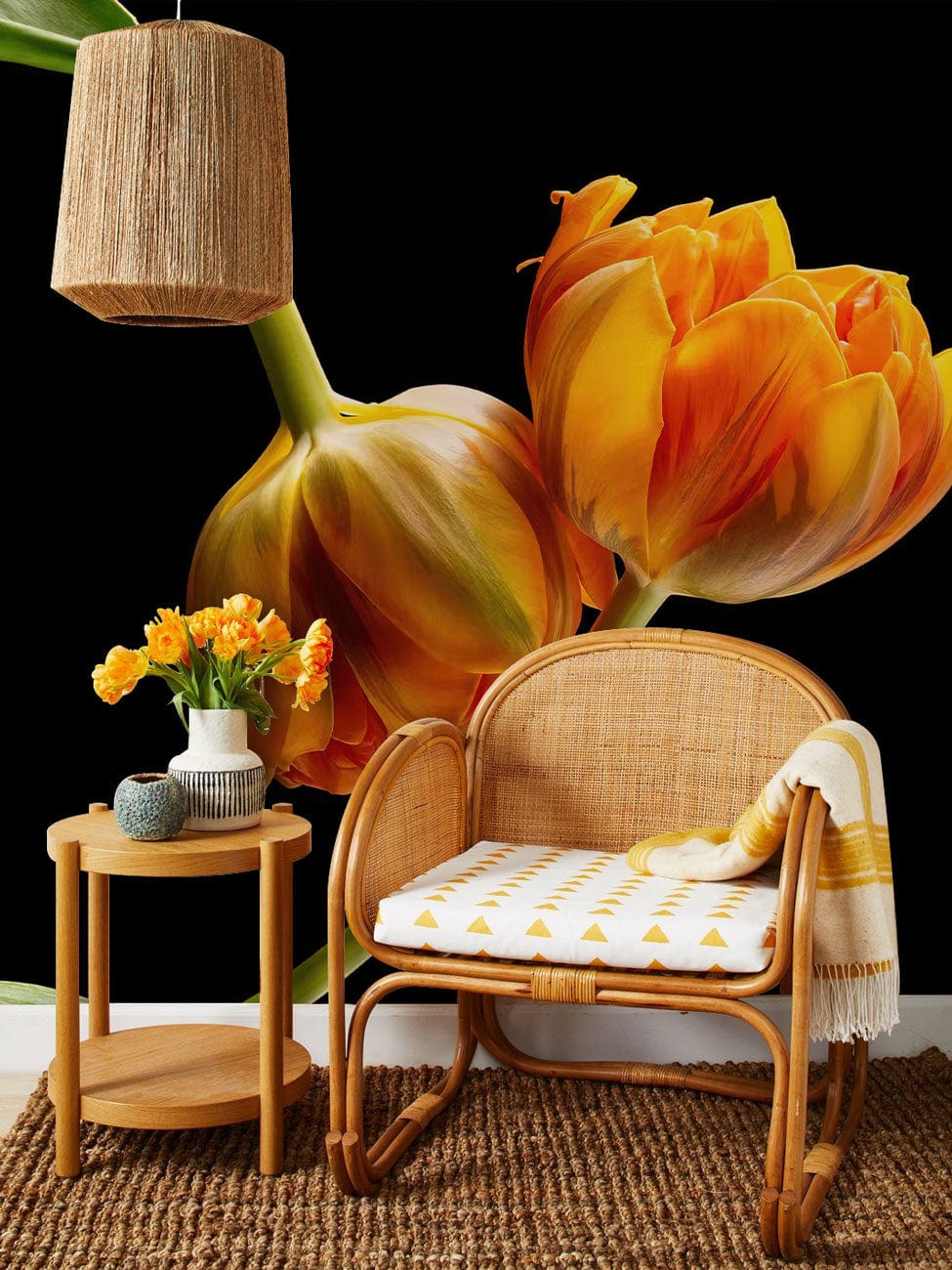 Vibrant orange tulip mural wallpaper, rattan chair, woven flooring, side table, contemporary botanical Décor.