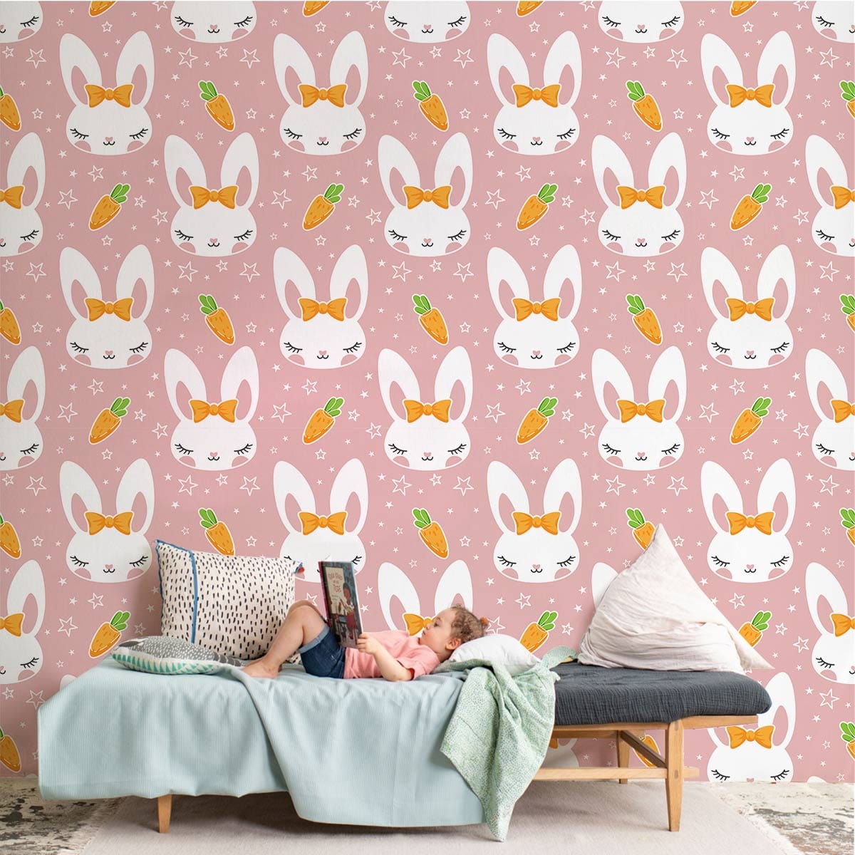 Adorable pink bunny and carrot wallpaper in kids' room with grey sofa, pillows, and plush rug.