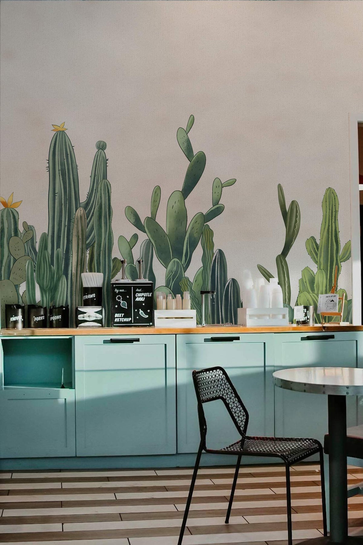 Modern kitchen with Vibrant Green Cactus Botanical Wallpaper Mural, blue cabinets, metal chair, striped flooring.