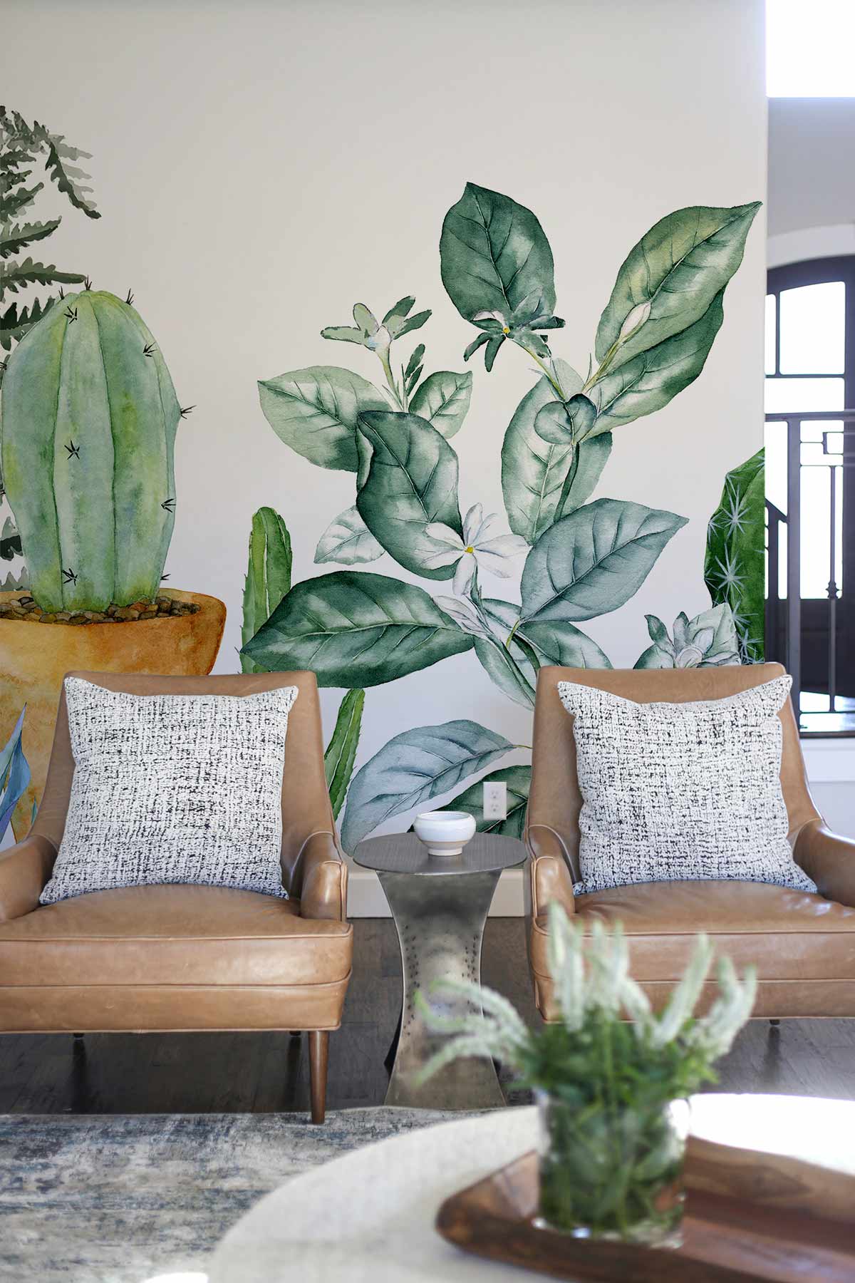 Botanical Oasis wallpaper with green cactus, ferns; brown leather chairs, modern room, light flooring.