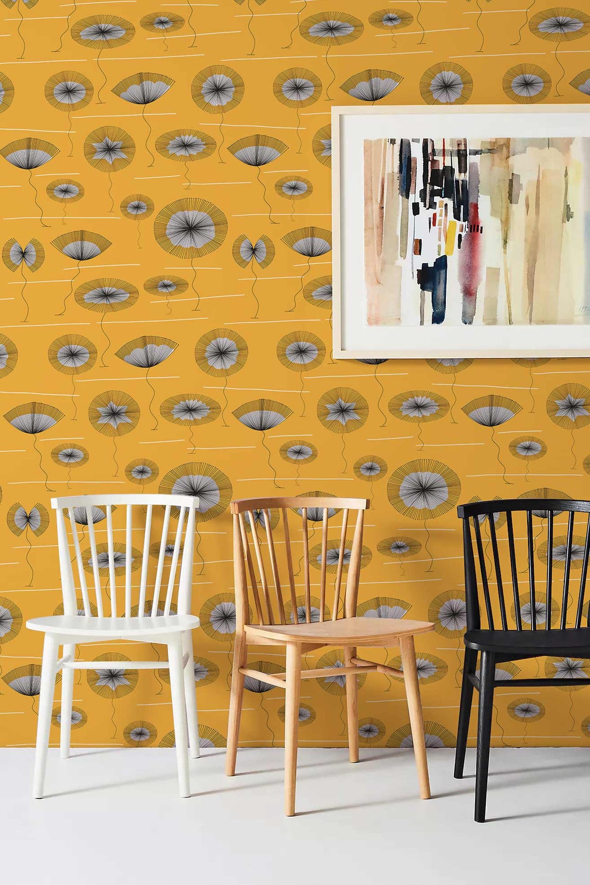 Retro mustard geometric wallpaper; white, natural, black chairs; abstract wall art; modern British interior design.
