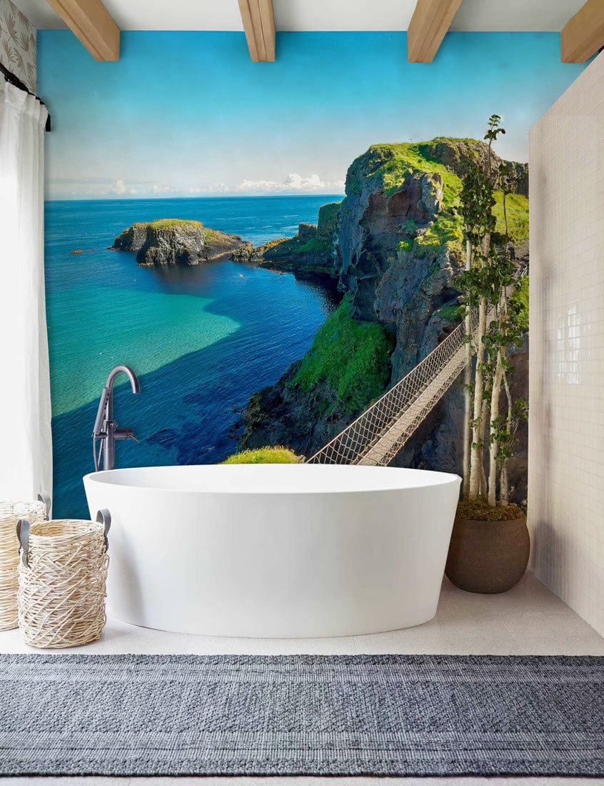 Tranquil Coastal Cliff mural wallpaper in vibrant greens and blues; modern bathroom with freestanding tub.