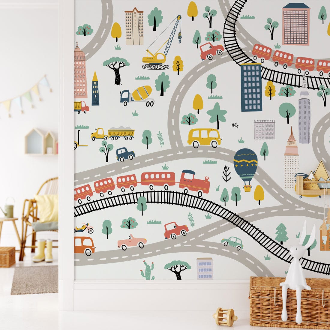 Children's room with Colourful City Adventure Wallpaper, featuring playful roads and vehicles; white walls, cosy chair.