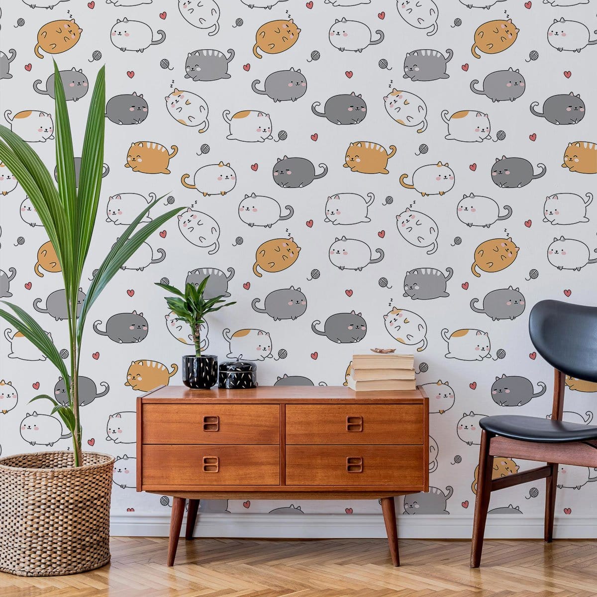 Charming cat wallpaper with grey, orange, and white; mid-century sideboard, black chair, wicker plant basket.