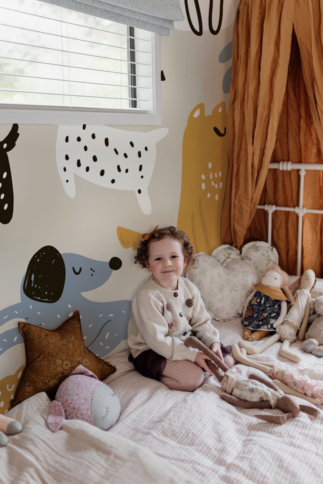 Child's room with whimsical canine parade wallpaper, earthy tones, white bed, and soft toys.