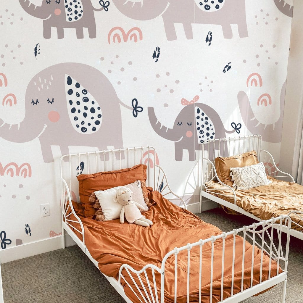 Grey Elephant Nursery Wallpaper with pastel patterns, white beds, orange bedding, soft carpet, children's room.