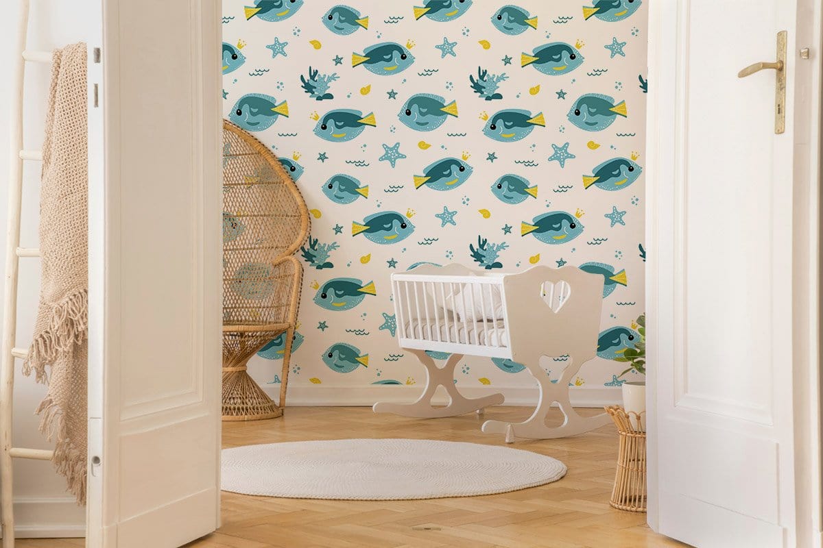 Children's room with Playful Blue Ocean Fish wallpaper, wicker chair, white cradle, light wood flooring.