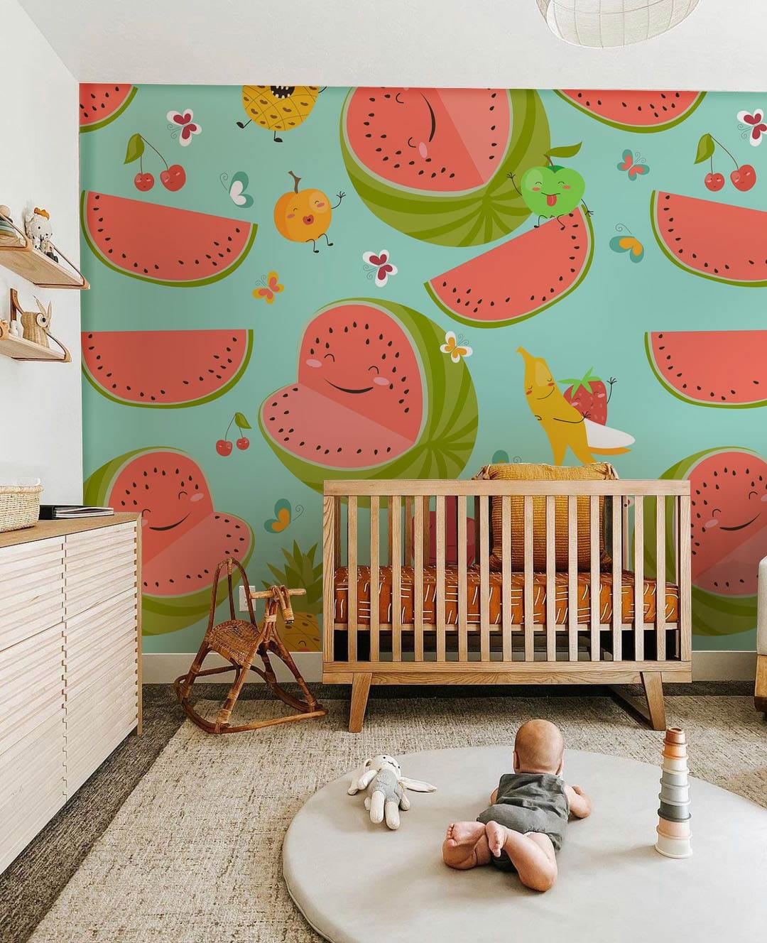 Nursery with Playful Pastel Fruit Cartoon Pattern Wallpaper, watermelon theme, wooden crib, neutral flooring.