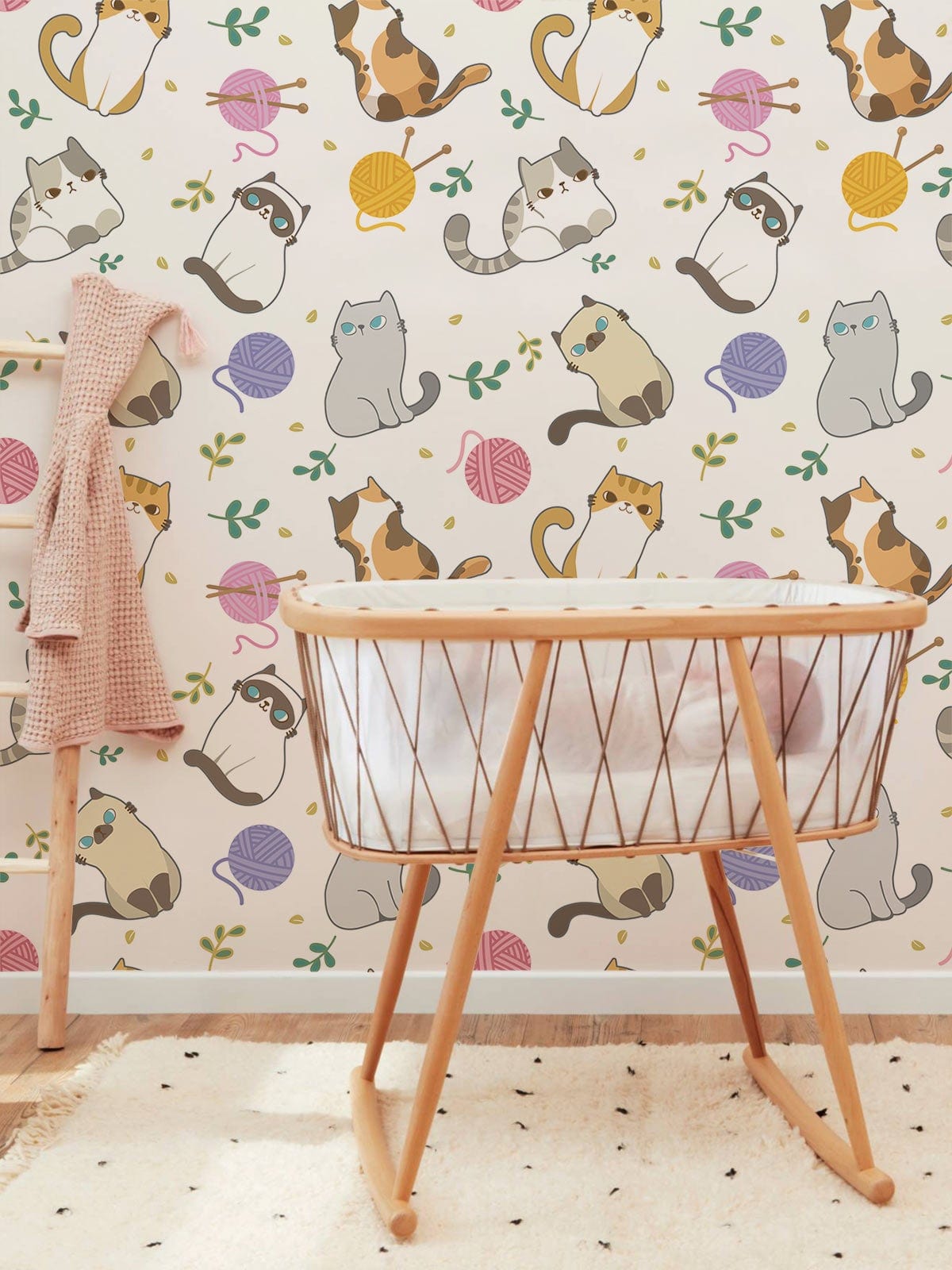 Playful pastel cat pattern wallpaper in nursery room features whimsical feline design and wooden cradle.