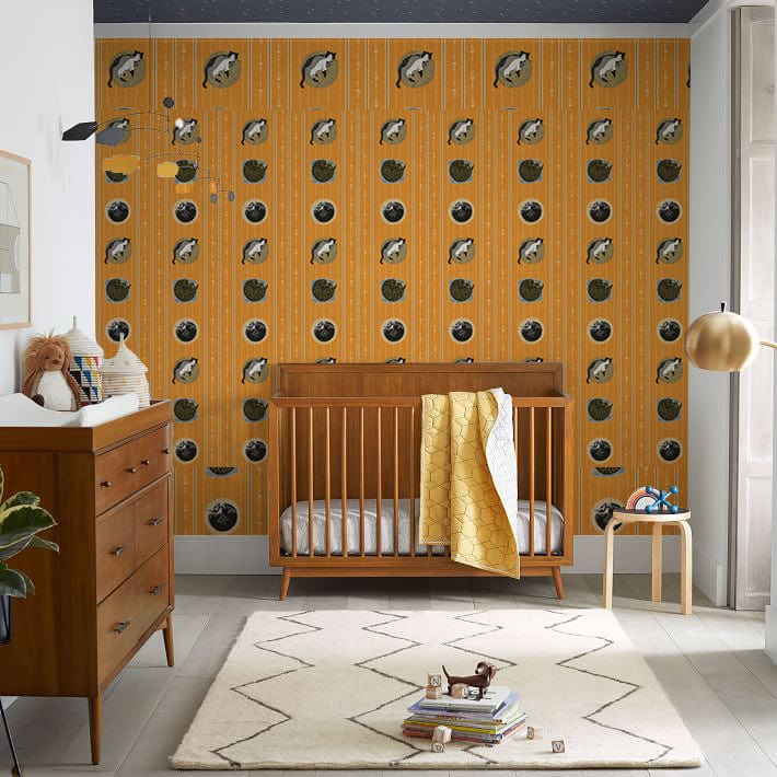 Cosy nursery with vintage orange nautical fish wallpaper, retro decor, wooden crib, and matching dresser.