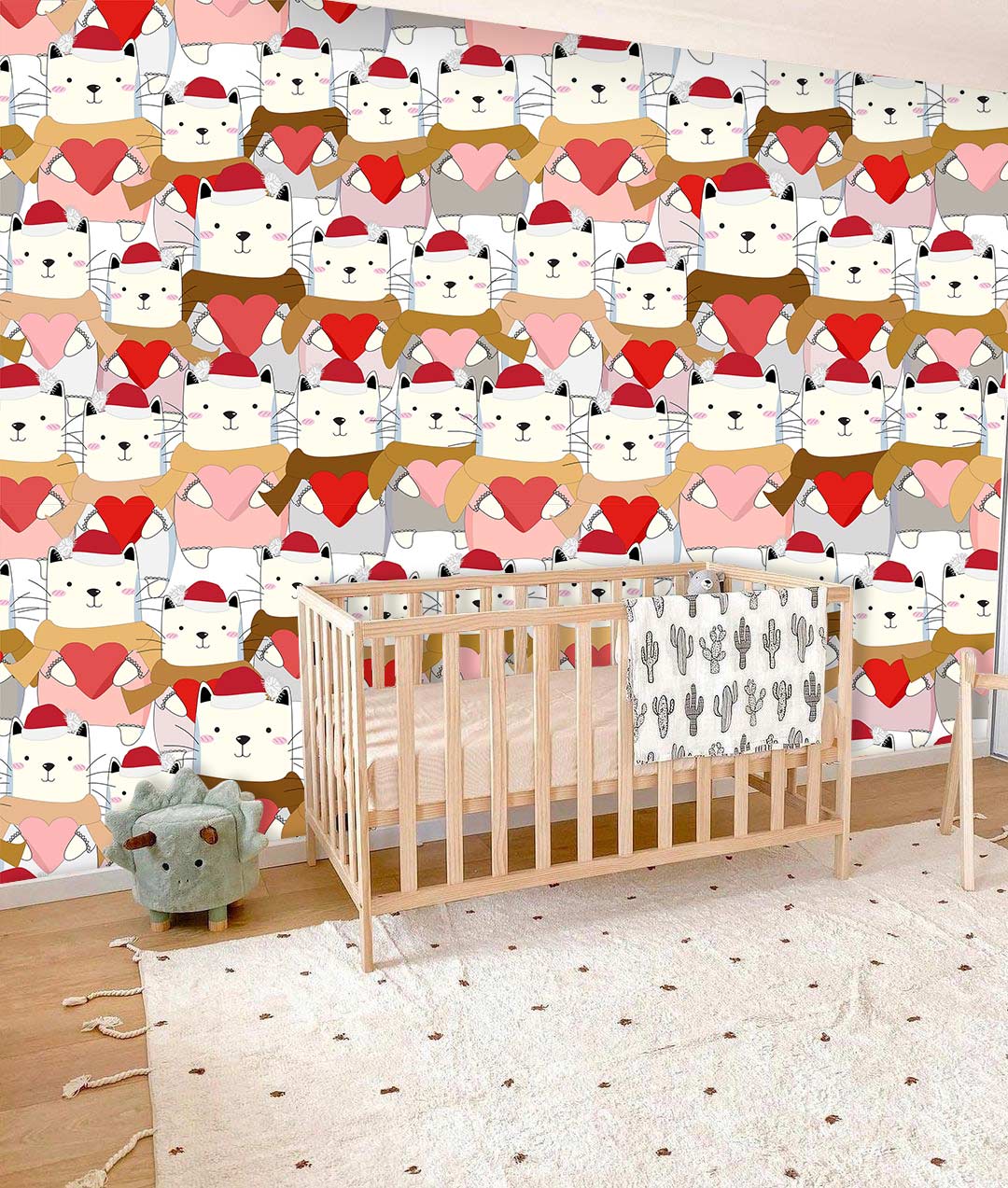 Festive cat pattern wallpaper, nursery with wooden cot, plush toy on wooden flooring, playful decor theme.