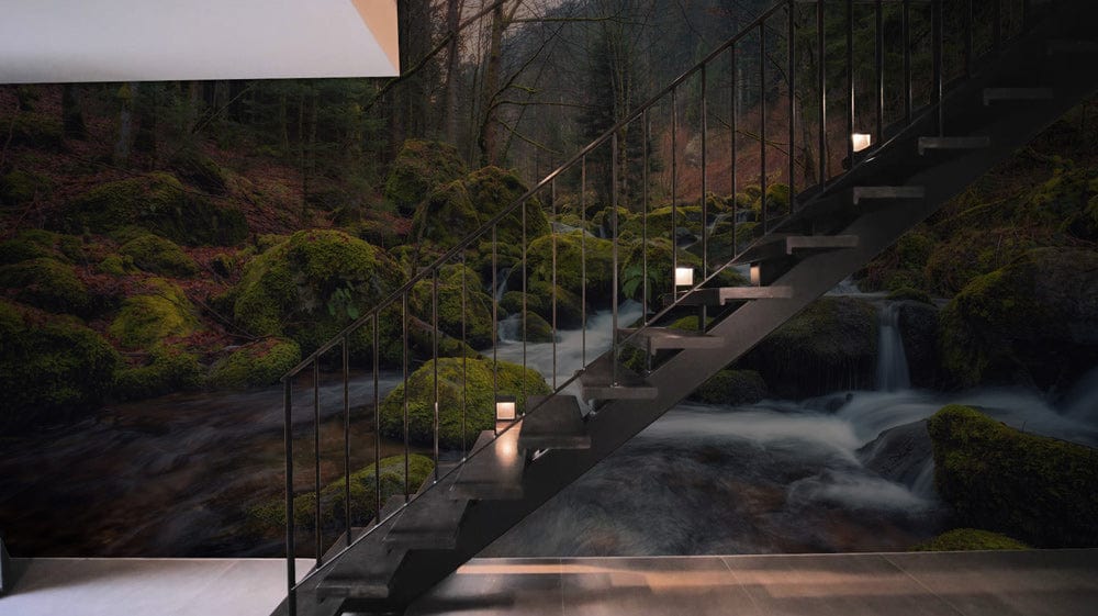 Modern hallway featuring Mystical Forest Stream Mural Wallpaper, elegant black staircase, and sleek grey flooring.