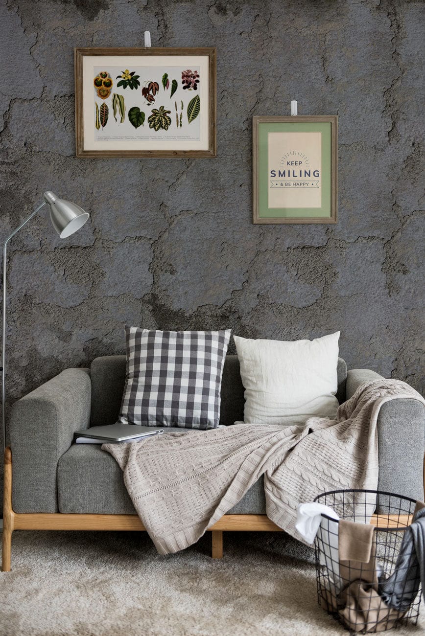 Industrial grey concrete effect wall mural with grey sofa, vintage decor, lamp, and framed artwork.