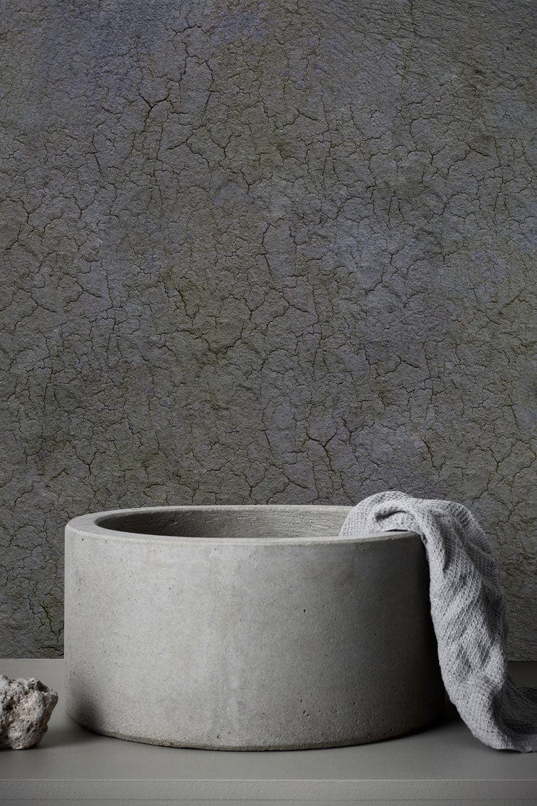 Textured grey cracked earth effect wallpaper, concrete sink, rustic interiors, minimalist bathroom decor.