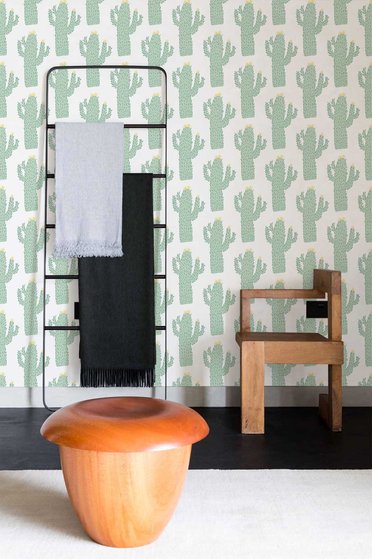 Green cactus wallpaper with wooden chair, metal towel rack, contemporary stool, black flooring, modern decor.