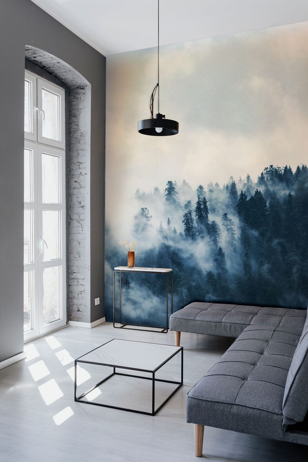 Misty Forest Landscape Mural on feature wall, grey sofa, modern room, light wood flooring.