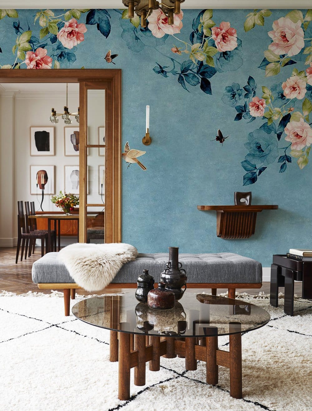 Floral Bliss: Sky blue and pink rose mural in vintage living room with grey sofa, wooden accents.