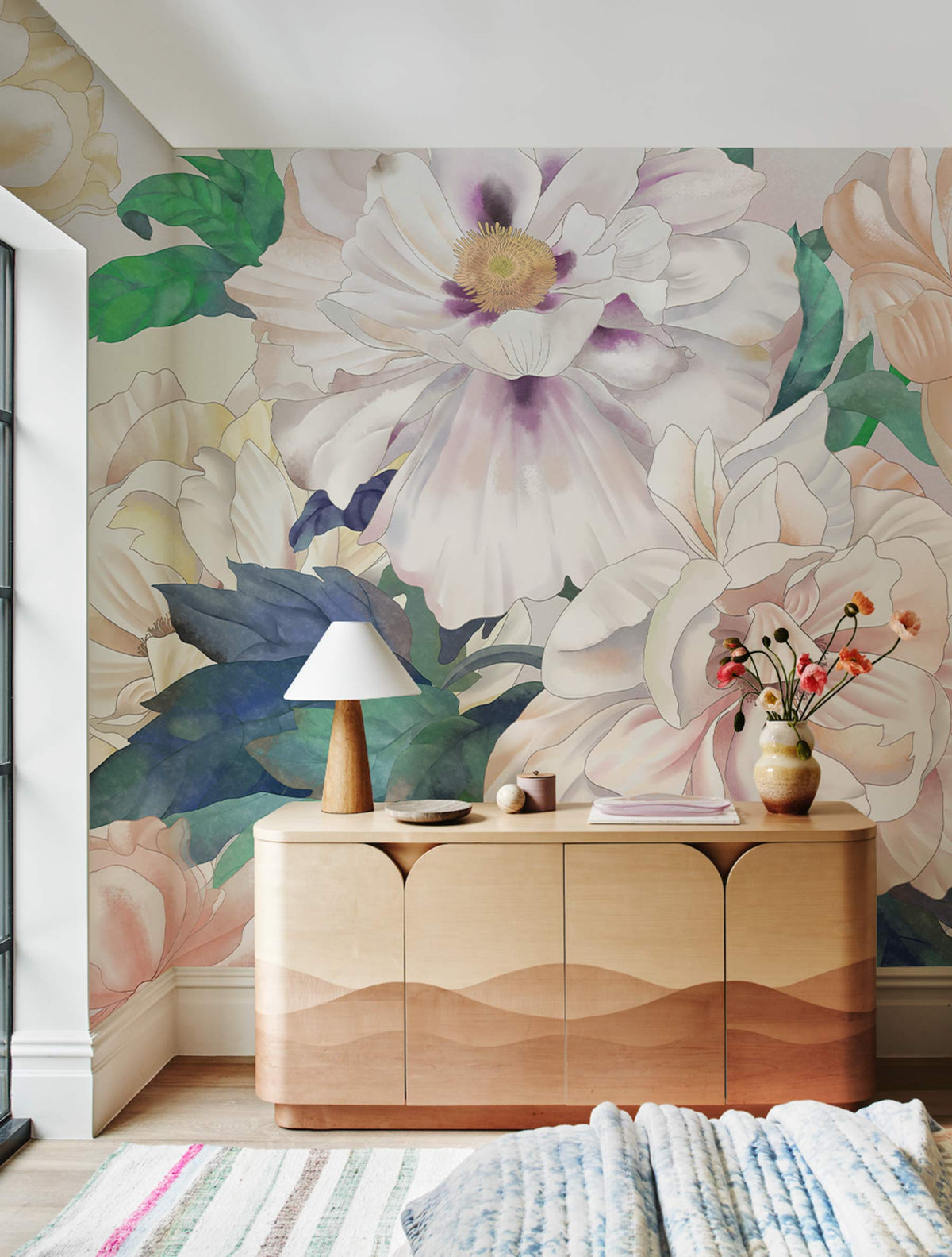 Elegant Pastel Blooms Mural Wallpaper in a living room with wooden sideboard, pastel rug, table lamp.