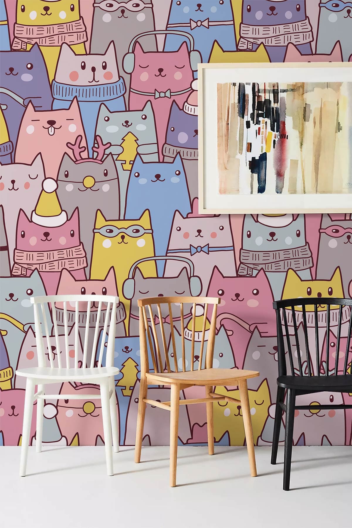 Whimsical pastel cat wallpaper in kids' room with colourful chairs and abstract painting on wall.