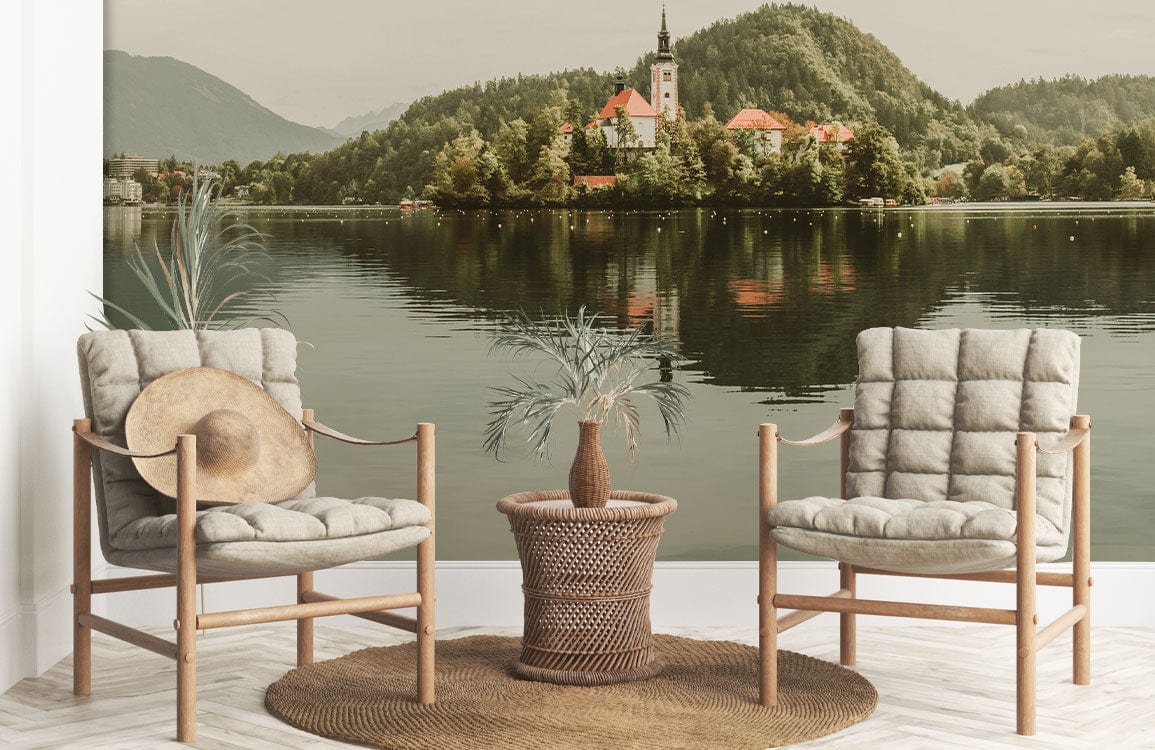 Charming lakeside mural wallpaper with armchairs and woven rug; Tranquil Lakeside Village design displayed.