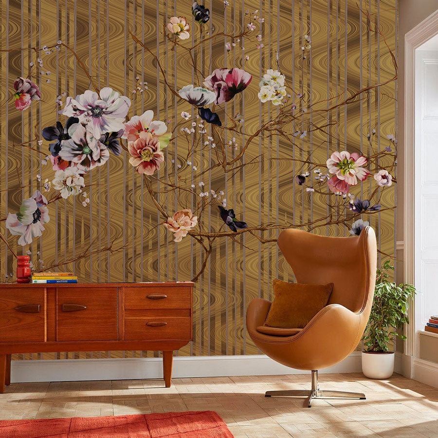 Elegant gold floral wallpaper with botanical design, mid-century sideboard, orange chair, light wood flooring.