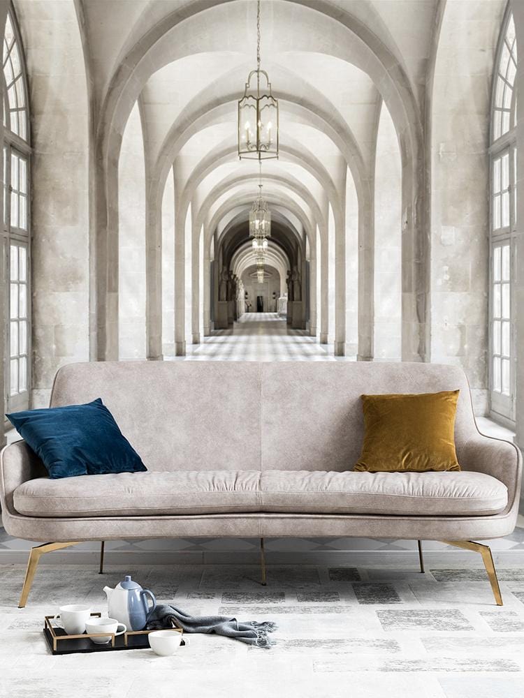 Elegant mural wallpaper in vintage neutral design with grey sofa, colourful cushions, and tiled flooring.