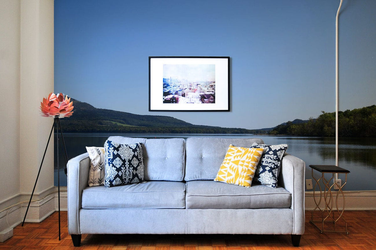 Tranquil Blue Lake mural wallpaper with grey sofa, wooden flooring, modern decor, and framed art.