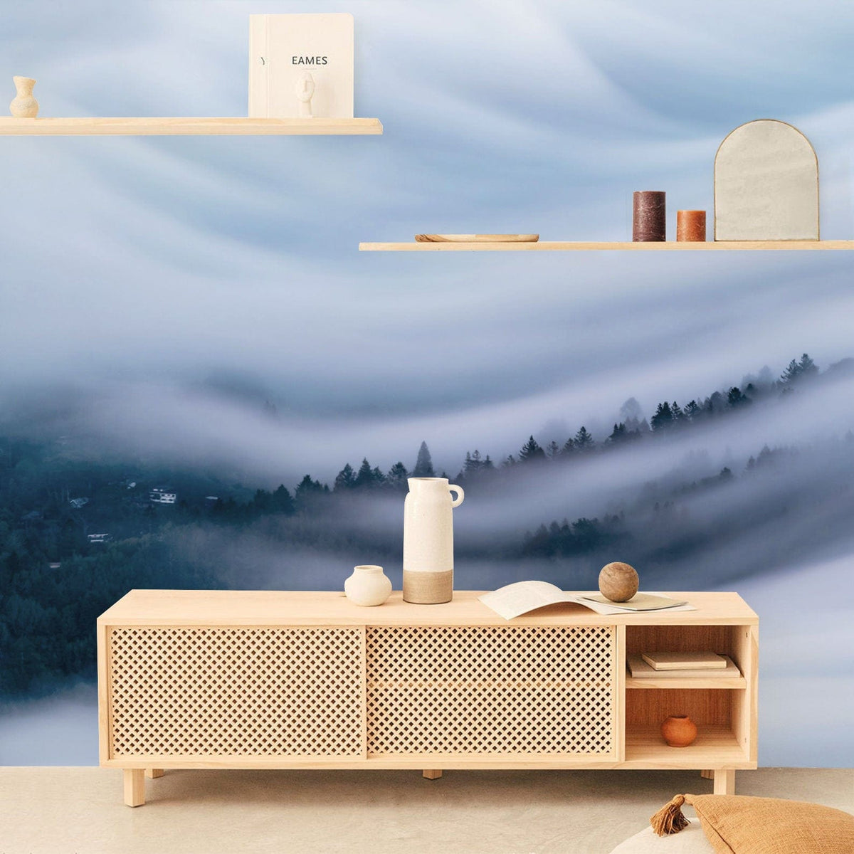 Tranquil Misty Forest wall mural, serene blue hues, light wood shelving, modern media cabinet, minimalist decor.