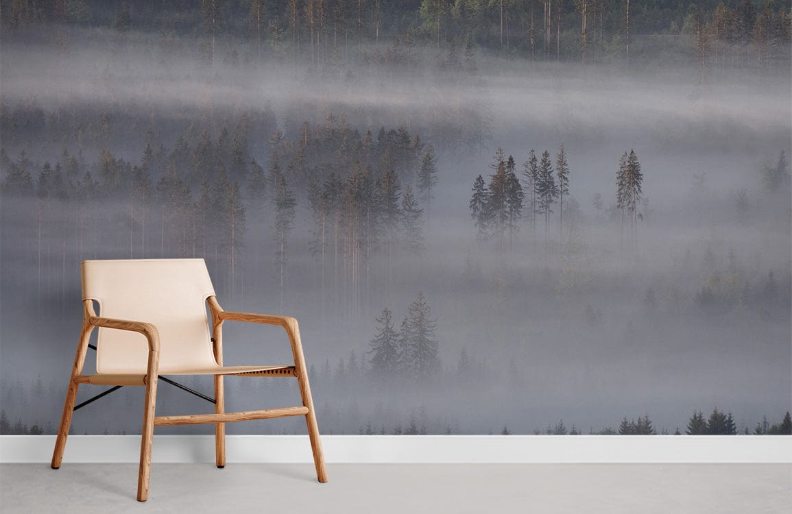 Misty forest mural wallpaper in grey and green tones, wooden chair, concrete flooring, modern setting.