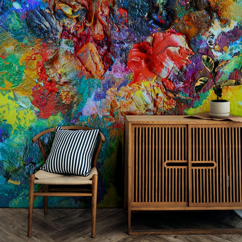 Vibrant abstract textured art mural wallpaper with wooden sideboard, striped cushion chair, herringbone flooring.