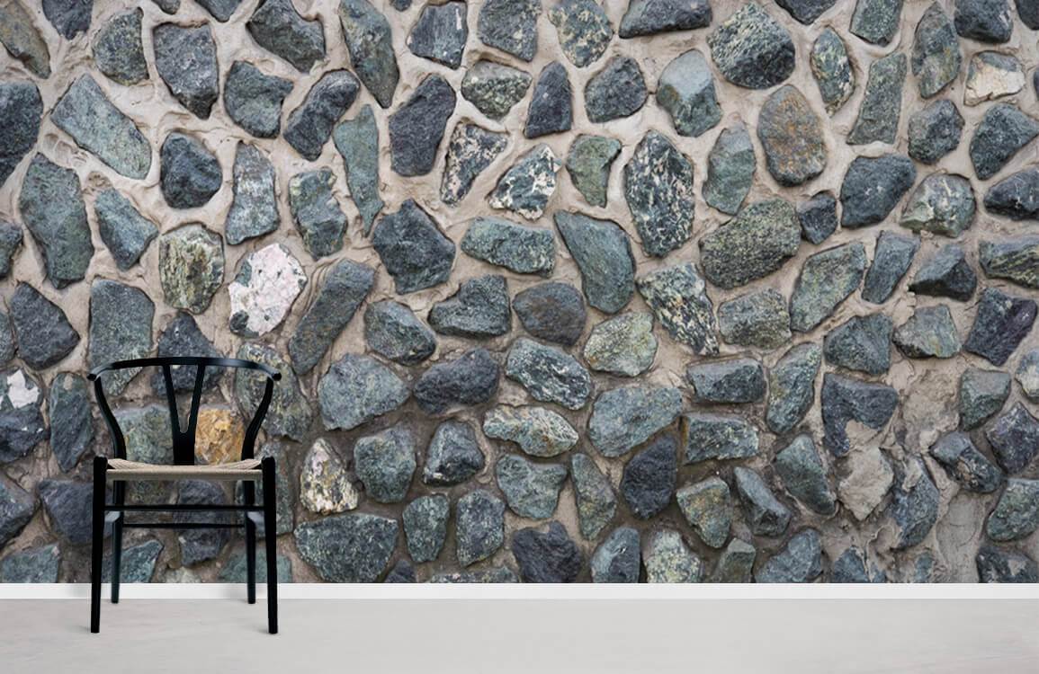 Rustic stone wall mural with natural pebble design, black chair, minimalist style, grey stone texture.