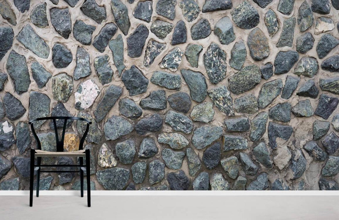 Rustic stone wall mural with natural pebble design, black chair, minimalist style, grey stone texture.