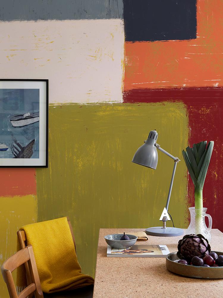 Geometric abstract colour block wallpaper, earthy tones, modern interior, yellow chair, cork table, framed art.
