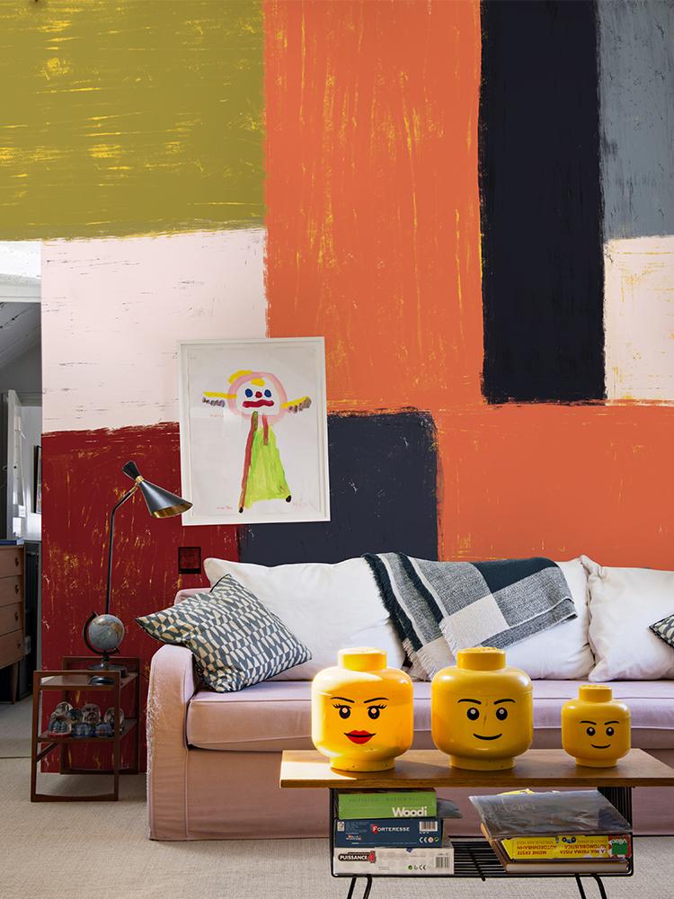Geometric Abstract Colour Block Wallpaper in earthy tones, modern sofa, stylish living room decor.