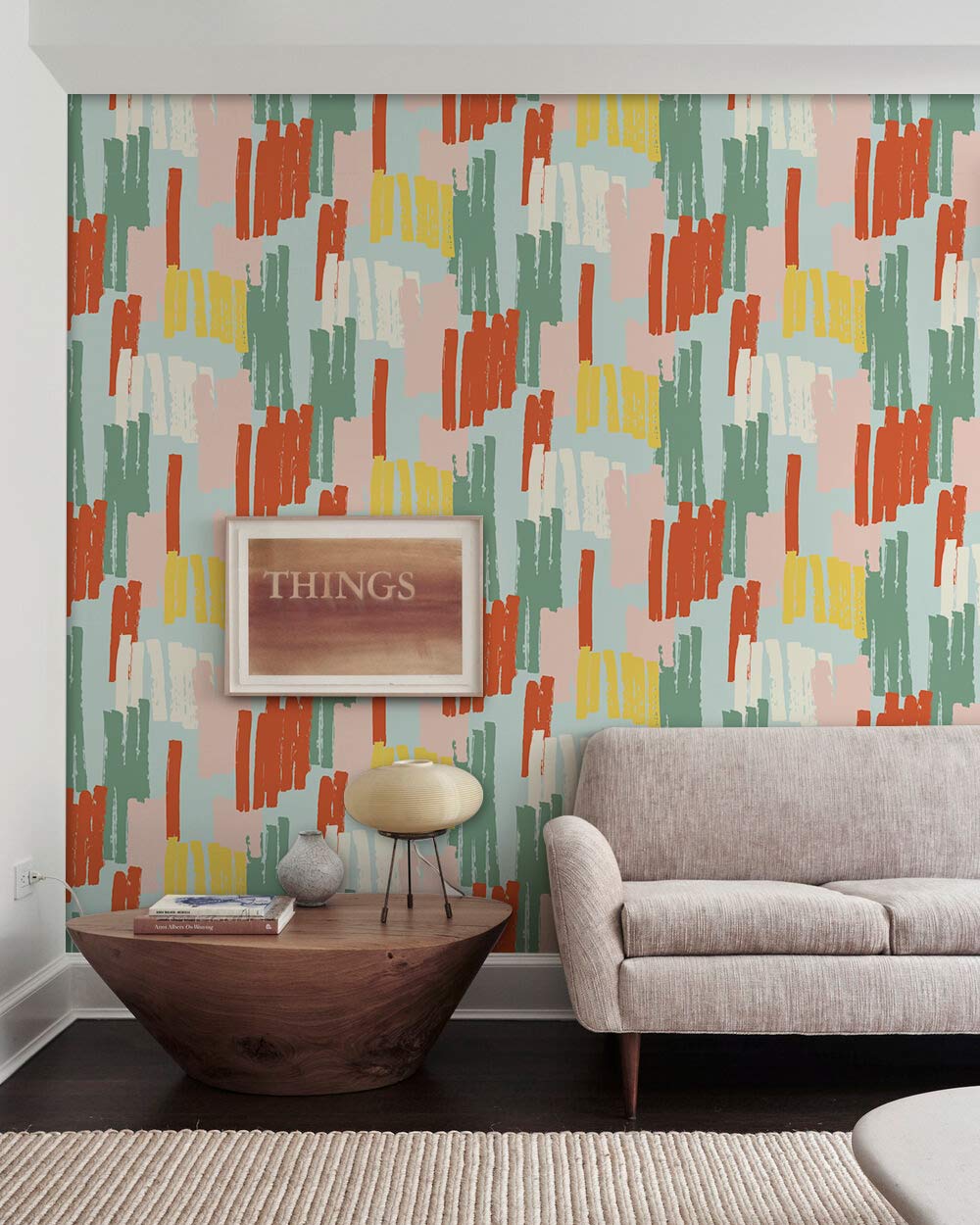 Vibrant abstract wallpaper in multicolour retro brushstroke design, featuring neutral sofa, wooden furniture.