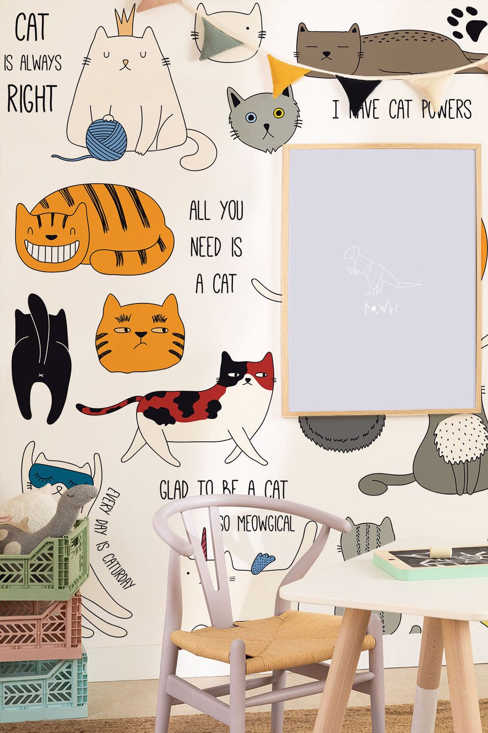 Colourful cat mural wallpaper with playful quotes for kids' room, featuring natural wood chair.