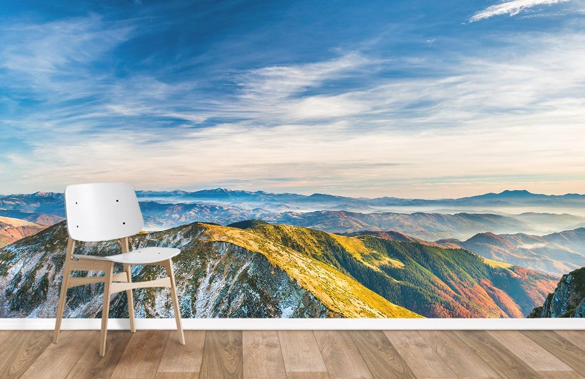 Majestic mountain mural in living room with wooden flooring, white chair, vibrant skies and serene nature.