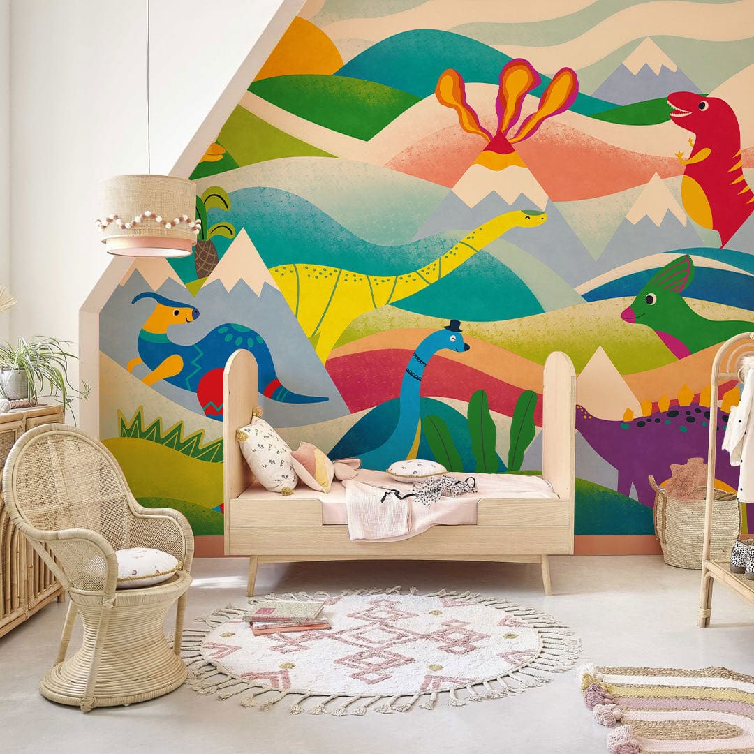 Colourful Dinosaur Adventure Mural Wallpaper in kids' room with wooden bed, woven chair, and patterned rug.
