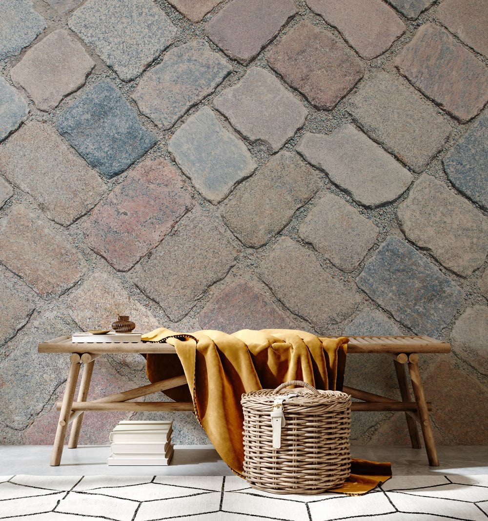 Rustic Cobblestone wallpaper with bench, yellow throw, wicker basket in stylish, modern living room.