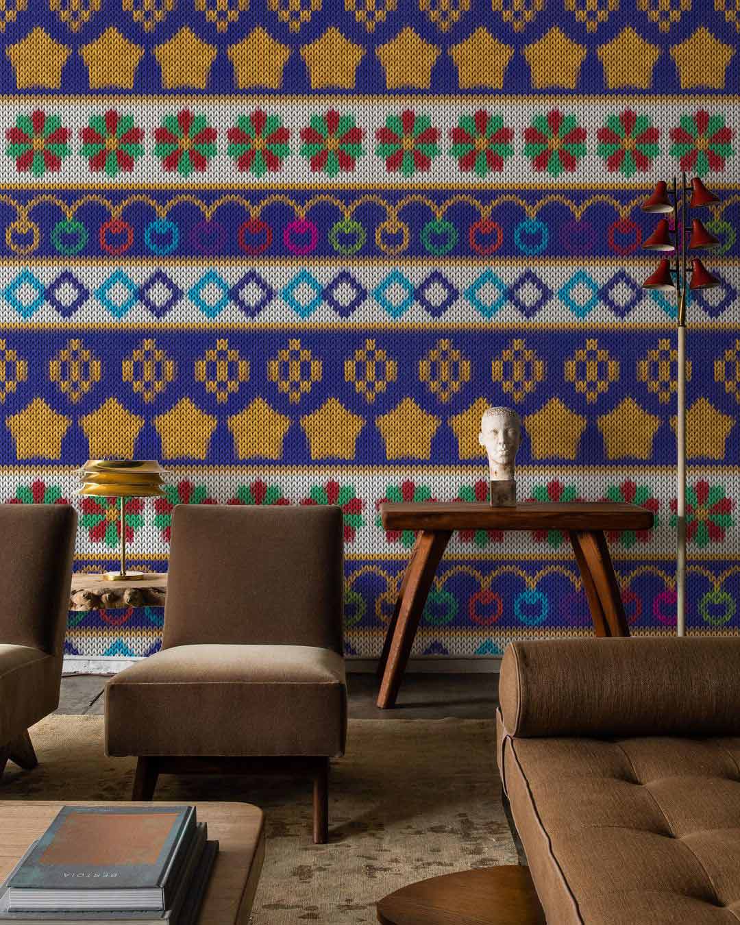 Vibrant multicoloured knitted wallpaper in living room with brown sofa, wood tables, and beige flooring.