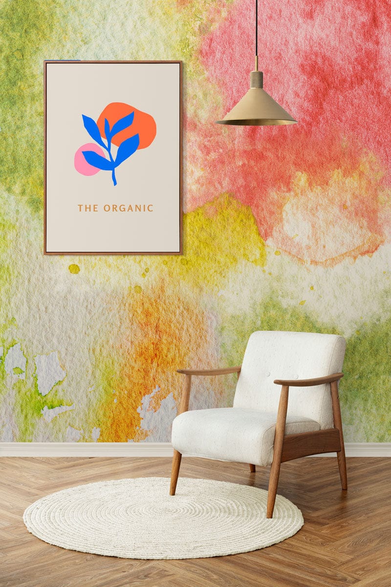 Vibrant watercolour wallpaper with armchair on wooden flooring in room with modern hanging lamp.