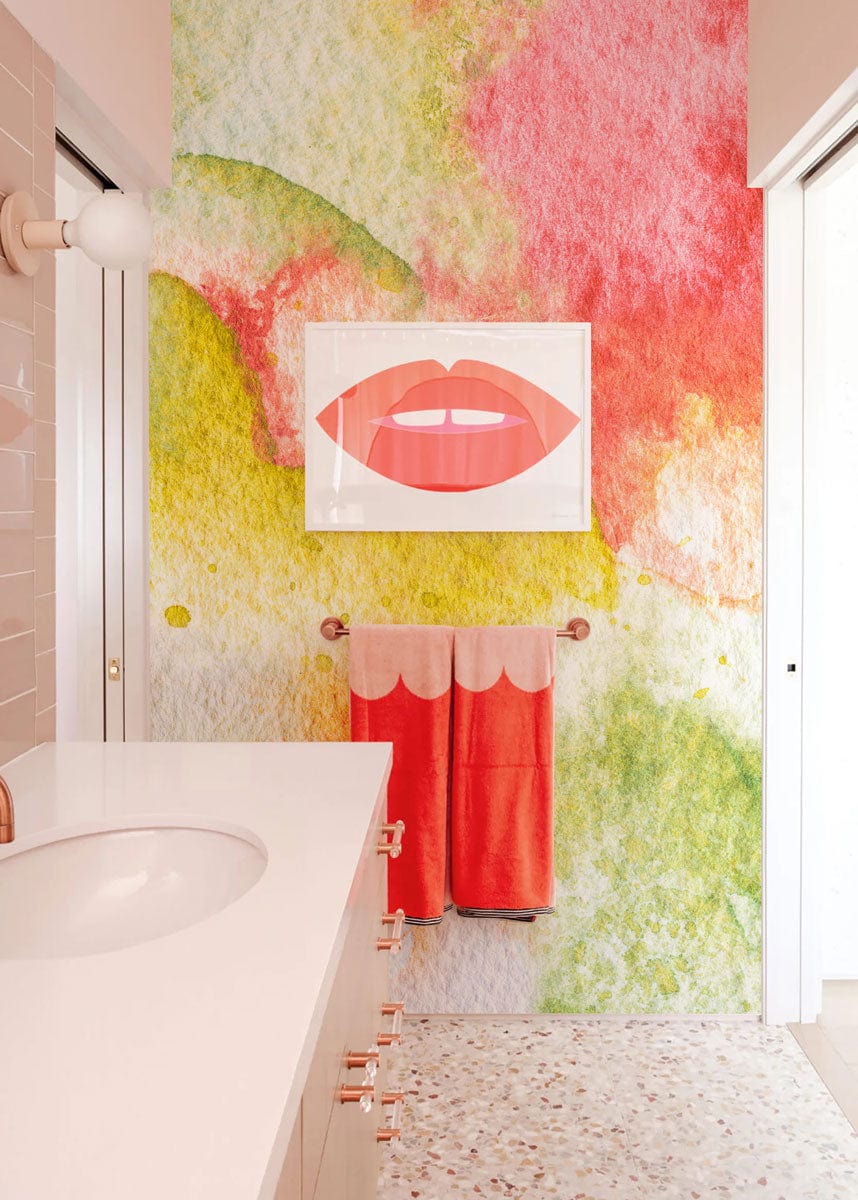 Vibrant watercolour abstract wallpaper in bathroom with terrazzo flooring and modern sink design.