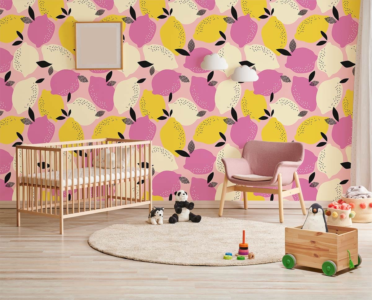 Nursery with pink and yellow lemon wallpaper, wooden crib, soft pink chair, light wood flooring.