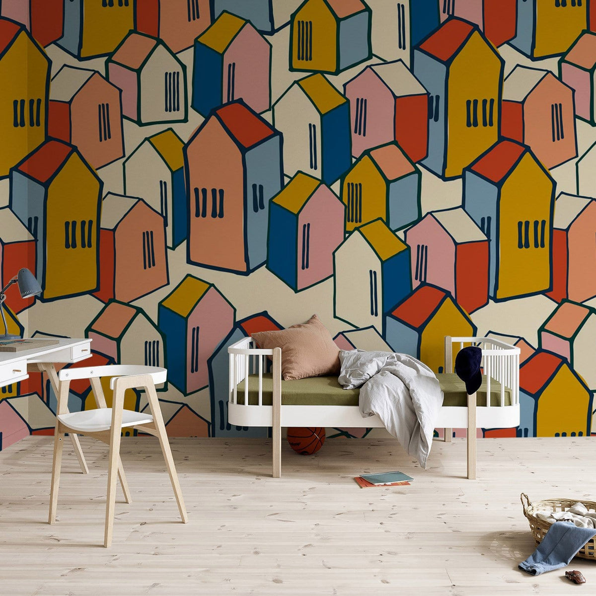 Colourful geometric houses wallpaper in artistic style, wooden flooring, modern chair, stylish bed, cosy room.