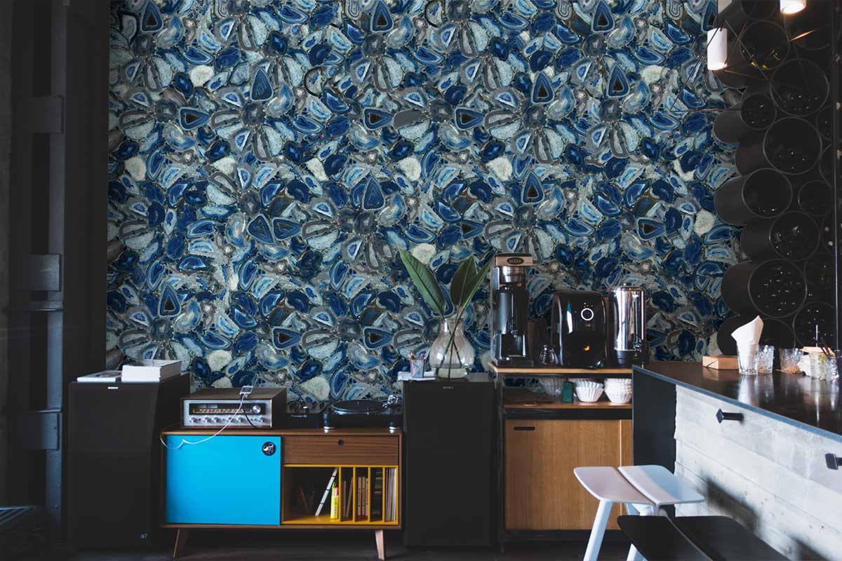 Elegant blue gemstone patterned wallpaper enhances modern kitchen decor with black shelves and stools.