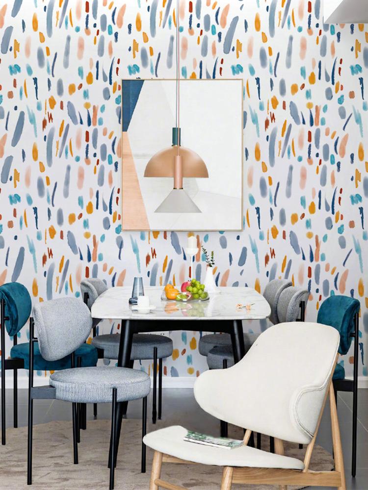 Abstract multicolour modern wallpaper with pastel hues, dining chairs, white marble table, framed wall art.