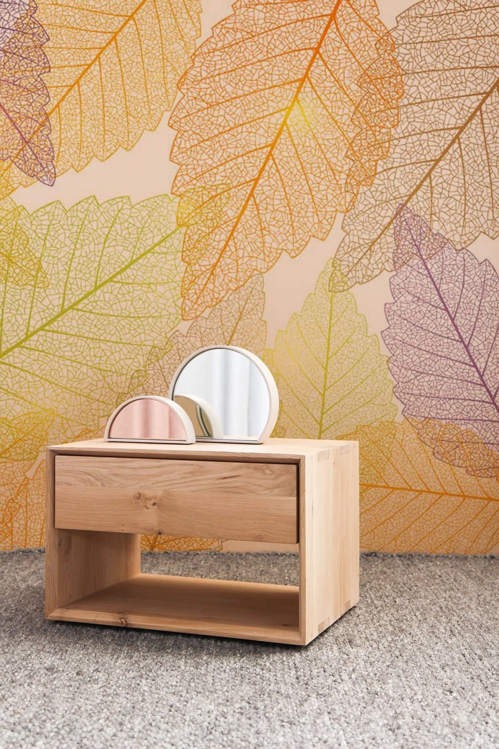 Elegant wallpaper with autumn leaf pattern features pastel yellow and green design, wooden furniture.