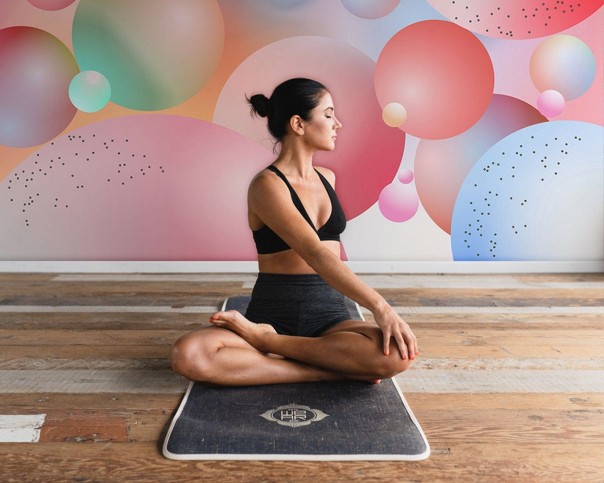 Pastel Bubble Dreamscape Abstract Mural Wallpaper in vibrant room, featuring wood flooring and yoga pose.