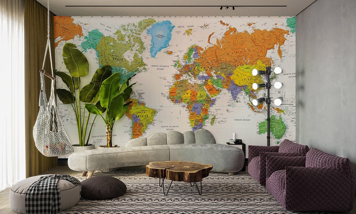 Colourful World Map Mural Wallpaper in living room with grey sofa, patterned rug, and dim lighting.